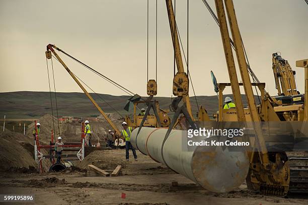 Pipeline worker guides a crane operator with a new section of natural gas pipe near Bainville, MT Sept 17, 2013. U.S. Pipeline Inc. Out of Houston,...
