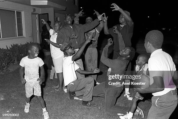 Members of the Grape Street Crips pose "throwing" their signature 'G' and 'W' hand signs. The Grape Street Watts Crips are a mostly African American...