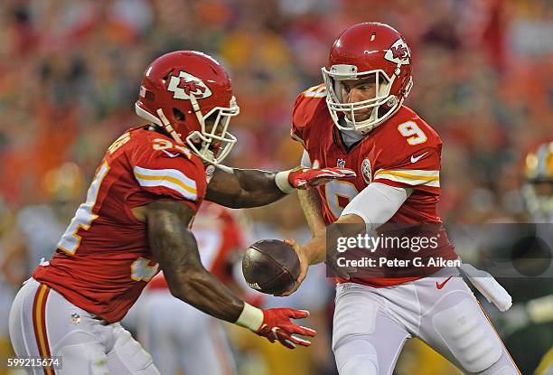 Quarterback Tyler Bray of the Kansas City Chiefs hands the ball off to running back Knile Davis against the Green Bay Packers during the first half...