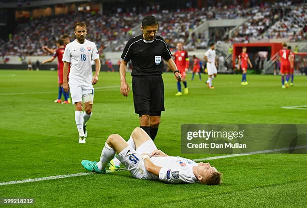 Referee Milorad Mazic stands over Tomas Hubocan of Slovakia as he is injured during the 2018 FIFA World Cup Group F qualifying match between Slovakia...