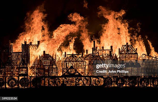 Metre long wooden model of London's 17th-century skyline burns on the River Thames after it was set alight in a dramatic retelling of the story of...