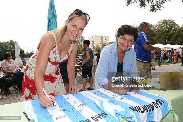 Stefanie von Poser and Monika Baumgartner sign T-shirts during the charity football game 'Kick for Kids' to benefit 'Die Seilschaft - zusammen sind...