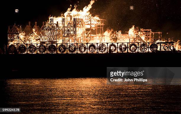 Metre long wooden model of London's 17th-century skyline burns on the River Thames after it was set alight in a dramatic retelling of the story of...