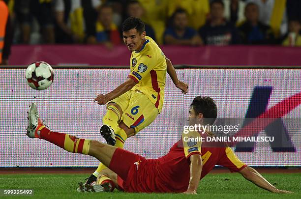 Romario Benzar of Romania vies with Nikola Vukcevic of Montenegro during the World Cup 2018 football qualification match between Romania and...