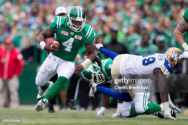 Darian Durant of the Saskatchewan Roughriders scrambles with the ball in the game between the Winnipeg Blue Bombers and Saskatchewan Roughriders at...