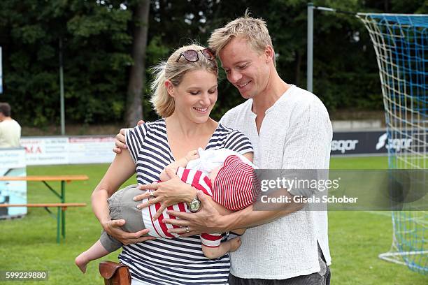 Eva-Maria Grein and her husband Christoph von Friedl and their baby son Jonathan during the charity football game 'Kick for Kids' to benefit 'Die...