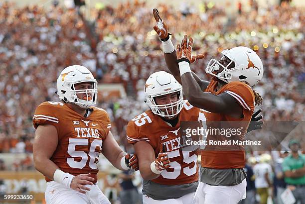 Armanti Foreman of the Texas Longhorns celebrates with teammates after scoring a touchdown during the first quarter against the Notre Dame Fighting...