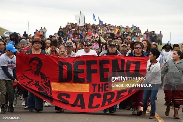 Native Americans march to the site of a sacred burial ground that was disturbed by bulldozers building the Dakota Access Pipeline , near the...