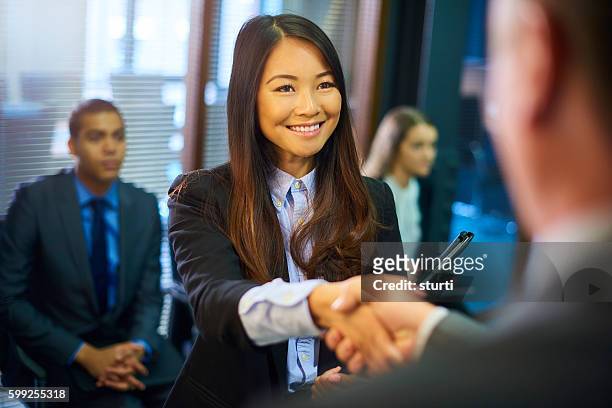 young woman's job interview - asian shaking hands stockfoto's en -beelden