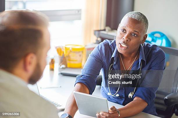 doctor diagnosis - androgynous professional stock pictures, royalty-free photos & images