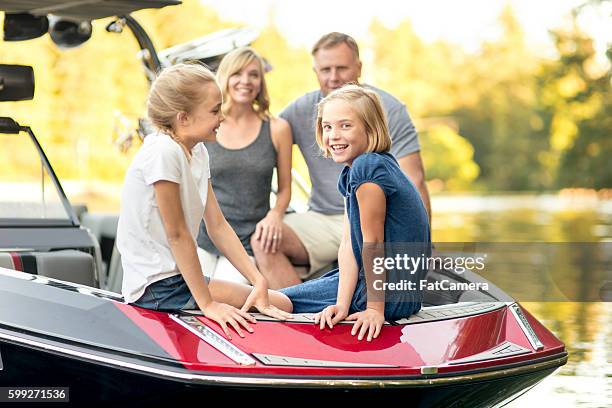 beautiful young family sits in their ski boat - motorboot varen stockfoto's en -beelden