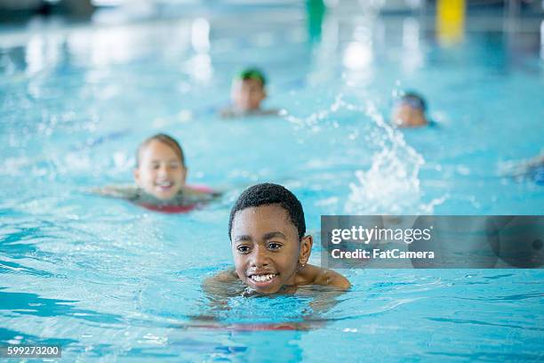 kicking through the water - children swimming stock-fotos und bilder