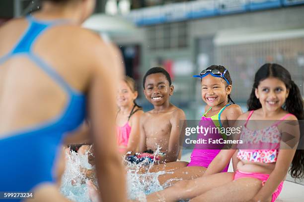 kicking together during swim class - leisure facilities stock pictures, royalty-free photos & images