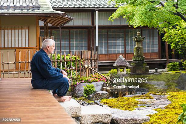 homme âgé dans le jardin du temple - karesansui photos et images de collection
