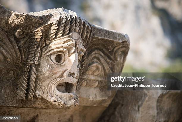 theater mask, man face with broken nose carved on stone in the archaeological site of myra, ancient lycian civilisation, southern turkey - stile greco classico foto e immagini stock