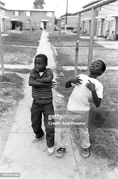 Young boys mimick their elder "homies" of the Grape Street Crips. The Grape Street Watts Crips are a mostly African American street gang based in the...