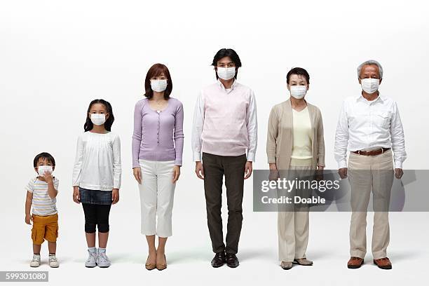 multi-generational family all wearing surgical masks - family side by side stock pictures, royalty-free photos & images