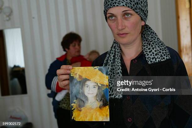 Mother displays a photo of her daughter, lost in the Beslan siege. 318 civilians, including 186 children, died during the three-day hostage crisis...