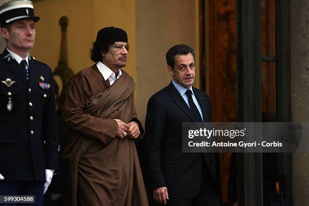 French President Nicolas Sarkozy walks Libyan leader Muammar Gaddafi to the gate of the Elysee Palace.