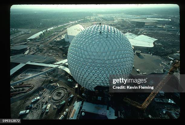 During the final stages of construction, workers bolt aluminum panels onto the frame of Spaceship Earth, the 180-foot-high geosphere that is the...