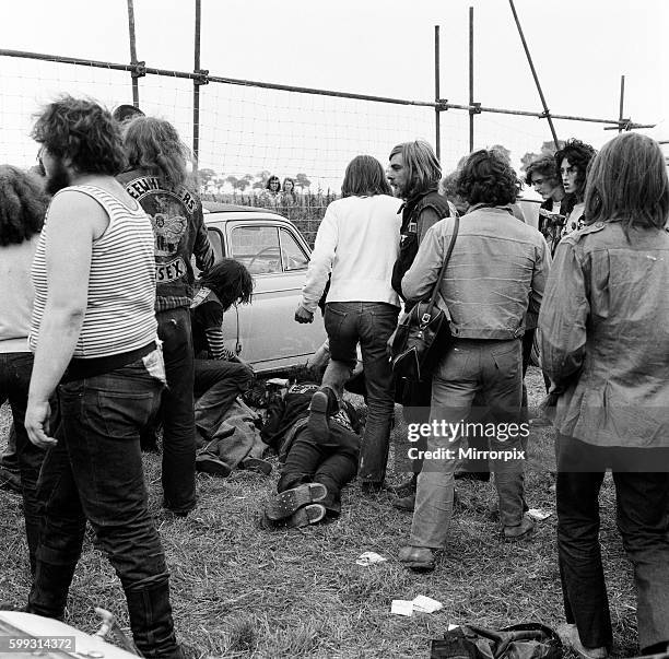 Scene at POP Festival, Weeley, Essex, following a battle between security men and Hells Angels, a young injured Hells Angel lays on the ground, 28th...