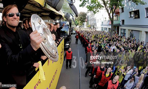 Die Mannschaft jubelt den Fans aus dem Bus zu Trainer Jürgen Juergen Klopp Borussia Dortmund mit Meisterschale Double Sieger Doublesieger Meister und...