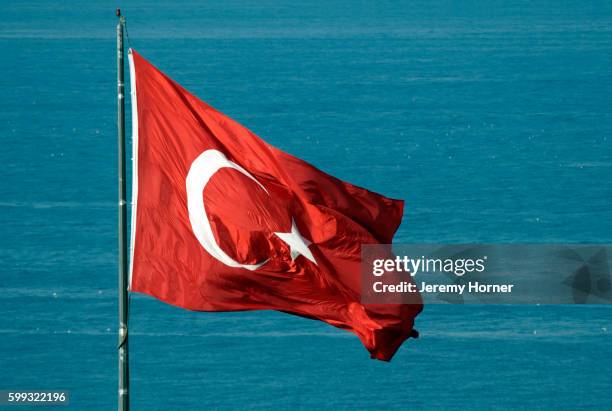 turkish flag over bosphorus strait - bandiera della turchia foto e immagini stock