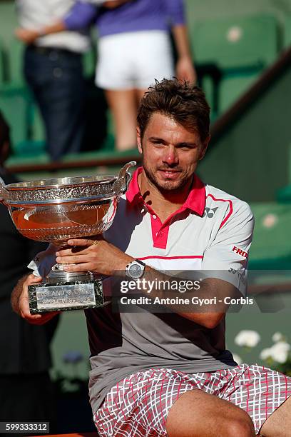 Stanislas Wawrinka of Switzerland poses with the Coupe de Mousquetaires after victory in the Men's Singles Final against Novak Djokovic of Serbia on...