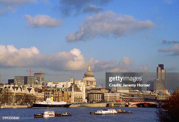 The dome of St. Paul's Cathedral, ca. 1708, rises above the multistory buildings of the city of London, situated on the banks of the River Thames.