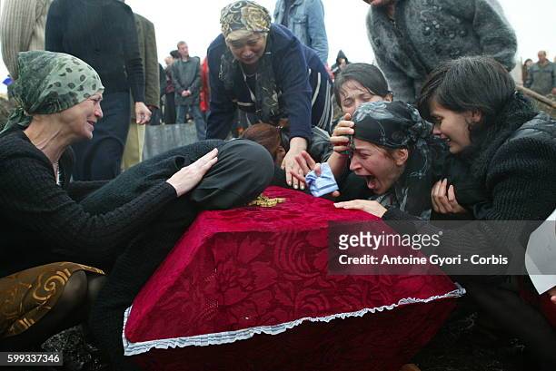 Svetlana Khoutsistova, surrounded by mourners, cries over the coffin of her son, Azamat, aged 26, who died in the Beslan school siege at Vladikavkaz...
