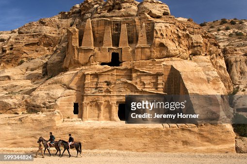 Horse riders passing Bab Al-Siq Triclinium at Petra