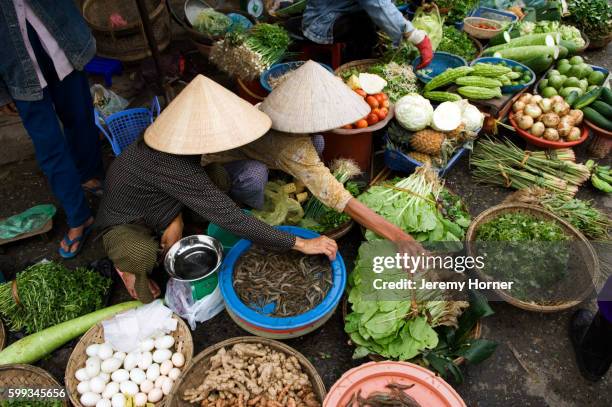 women tending produce stand - vietnam market stock pictures, royalty-free photos & images