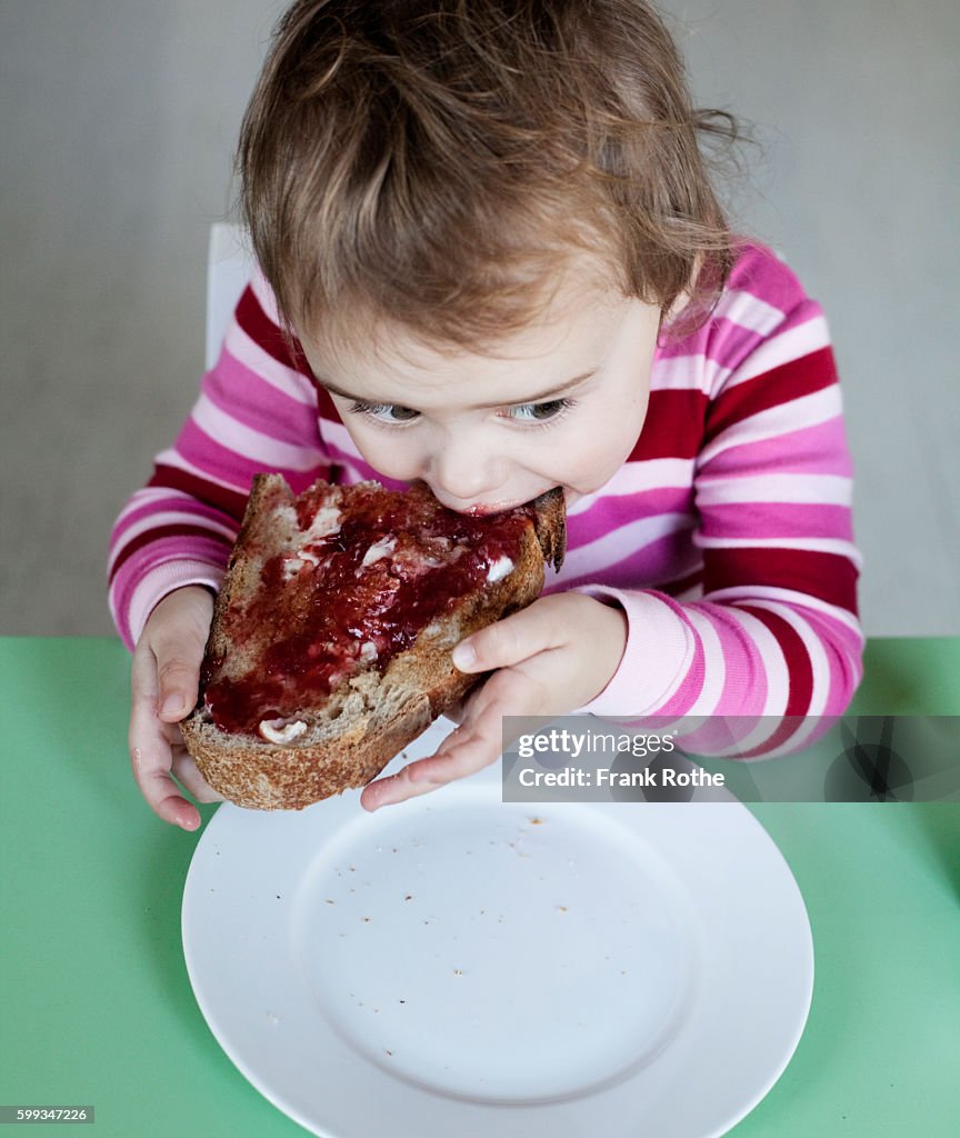 Small girl (2-3 years) eating sandwich