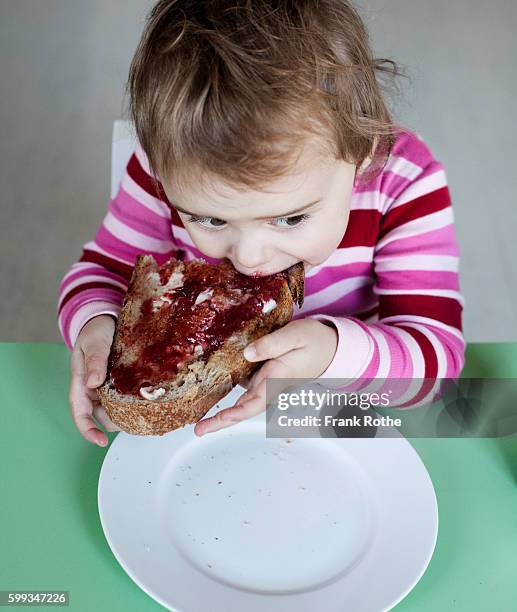 small girl (2-3 years) eating sandwich - marmalade sandwich stock pictures, royalty-free photos & images