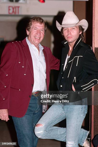 Buck Owens and Dwight Yoakam stand together in a recording studio. Owens is a country legend and former host of Hee Haw. Yoakam is a country...