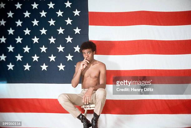 Comedian Richard Pryor picks his nose in front of an American flag in a photo session. Pryor is satirizing America's perceptions of itself and...
