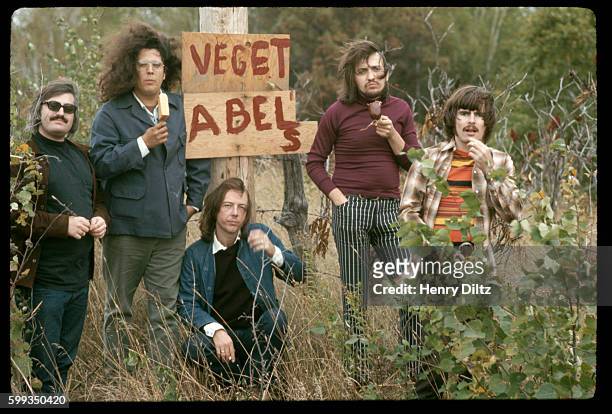 Two members of the 1960s folk-rock band, The Turtles, defiantly eat meat on a stick at either side of a "Veget-ables" sign. They became popular for...