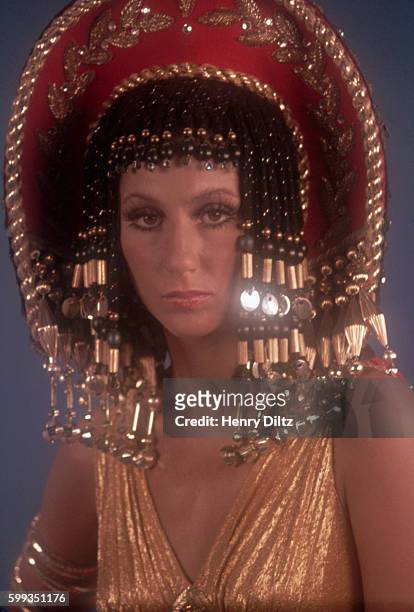 Singer and actress Cher wears an Egyptian-style headdress and braids.