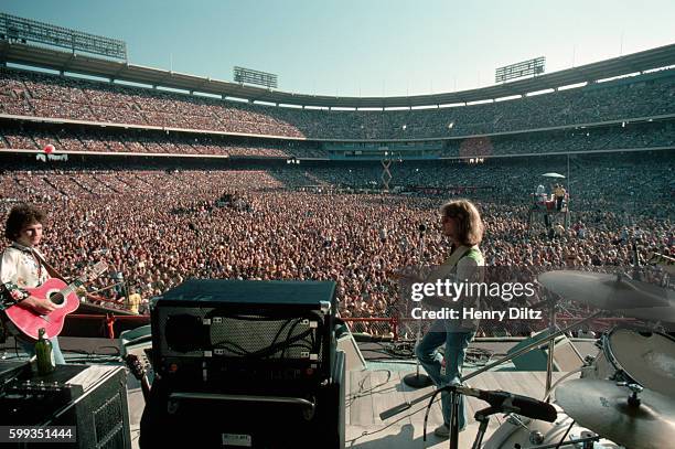 Gerry Beckley, Dewey Bunnell , and Dan Peek of folk-rock trio America play a live concert in Anaheim Stadium. America is best remembered for the...