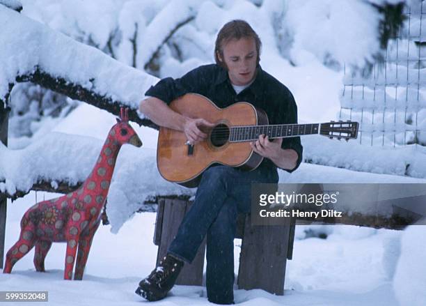 Folk-rock singer Stephen Stills plays a guitar in a snow covered meadow in Colorado. Stills became well-known in Buffalo Springfield, then moved on...