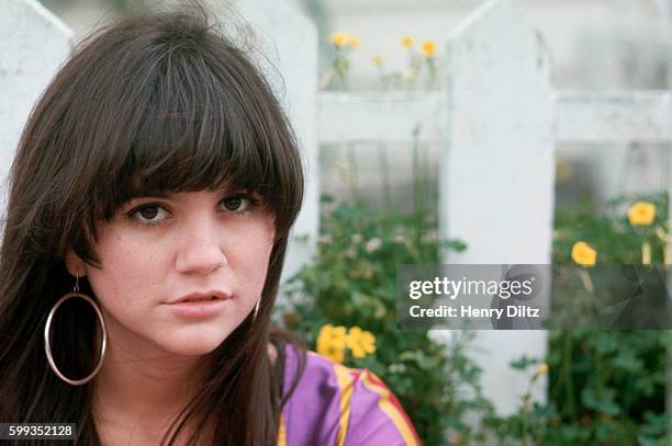 Singer Linda Ronstadt rests beside a fence. She became a major singing star in the seventies with a mix of country and rock backed by The Eagles....