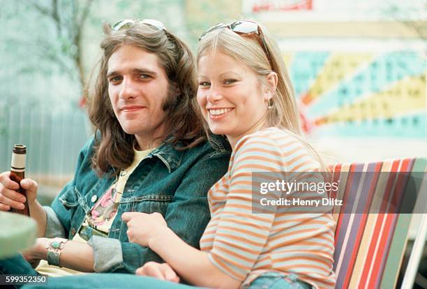 Woman snuggles with The Eagles' Glenn Frey, backstage at Wembley Stadium, London. The Eagles were the most popular band of the seventies and their...