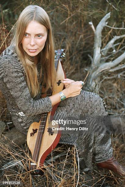 Singer-songwriter Joni Mitchell rests in a meadow with a mountain dulcimer at her Laurel Canyon home. Mitchell remains one of the most acclaimed...
