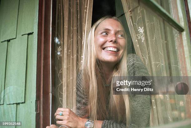 Singer-songwriter Joni Mitchell looks out of a window at her Laurel Canyon home, 1970.