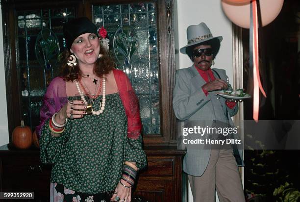 Singer-songwriter Joni Mitchell attends a Halloween party as a stereotypical black pimp.