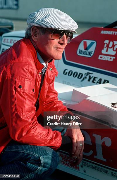 Paul Newman, actor and autoracer, crouches beside Mario Andretti's Formula One car at the Atlanta Raceway for the Atlanta International.