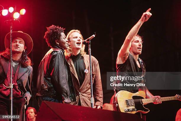 The members of the "Human Rights Now!" world tour sing together in a row at the Los Angeles show. From left, special L.A. Guest Bono, of U2, Tracy...