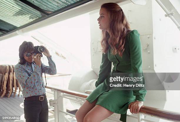 David Cassidy photographes Susan Dey as they wait on deck for their call to the set on the Fairseas cruise ship where they are filming of an episode...