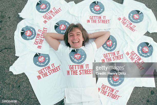 Actor and singer David Cassidy lying on the ground among Australian promotional t-shirts in Los Angeles, California.