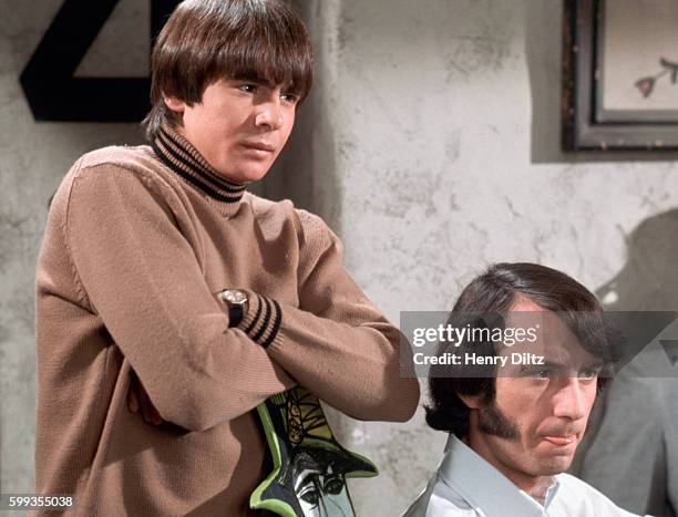 Davy Jones stands over Mike Nesmith in a skit on The Monkees television show.